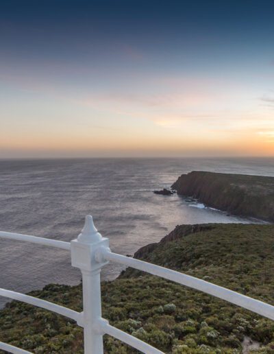 Woman enjoying the view from the balcony of Cape Bruny Lighthouse at sunset, Bruny Island, Tasmania