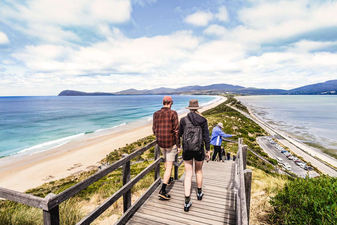 A man and woman walking down the stairs at the neck lookout, Bruny Island, Tasmania