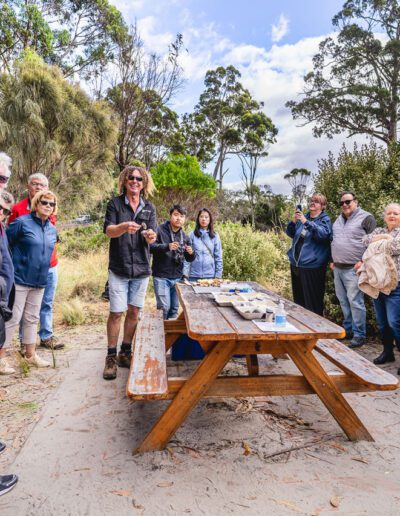 A tour group waiting to eat morning tea by the beach on Bruny Island