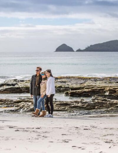 Guests taking a photo on the beach at Adventure Bay, Bruny Island, Tasmania
