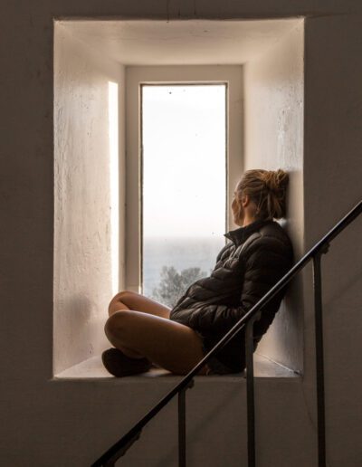Woman admiring the view from the window inside Cape Bruny Lighthouse
